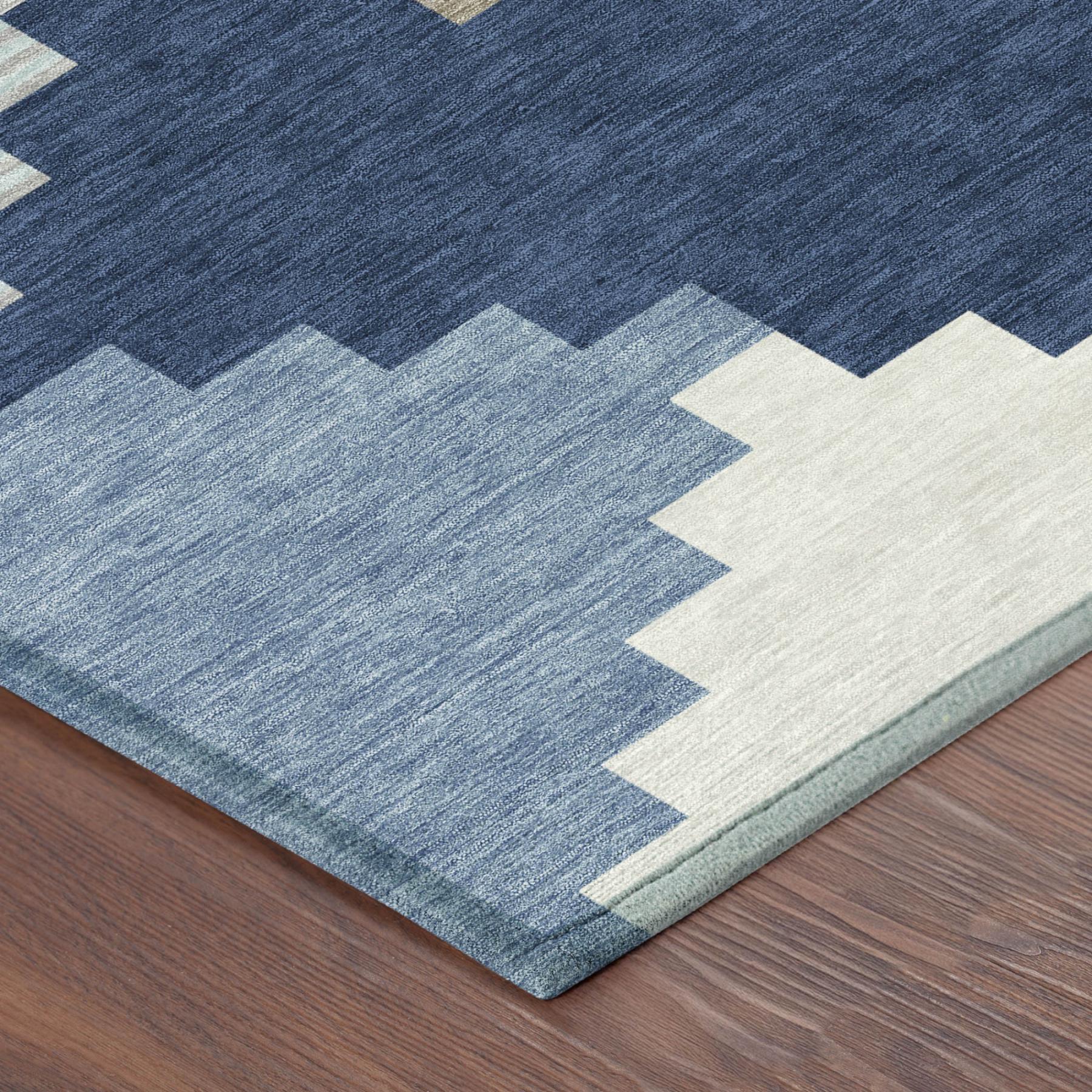 Blue indoor/outdoor area rug corner with textured geometric pattern and beige blocks