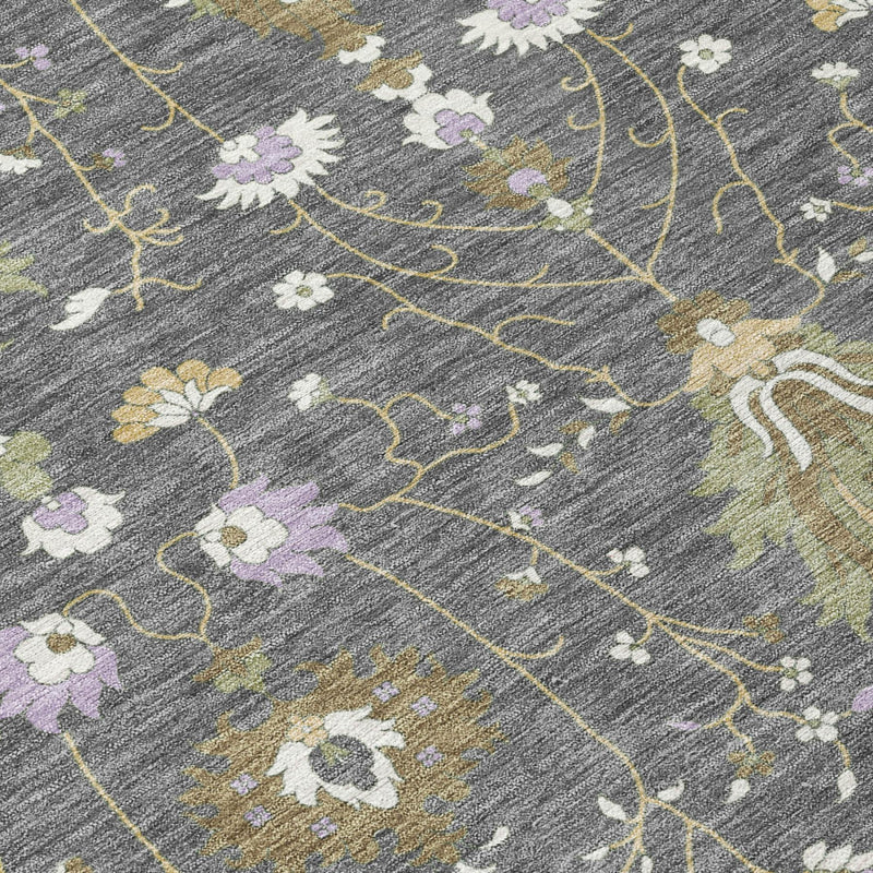 Gray oriental area rug close-up with yellow-green vine lines and white/lavender flowers.