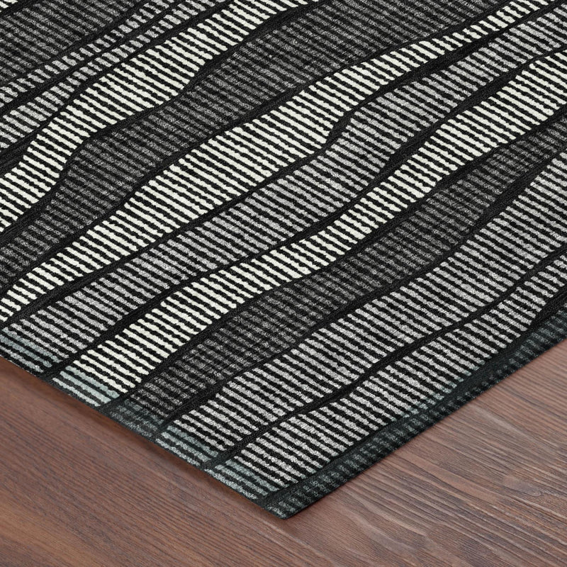 Corner view of black and graphite wavy-striped area rug with thin edge trim.