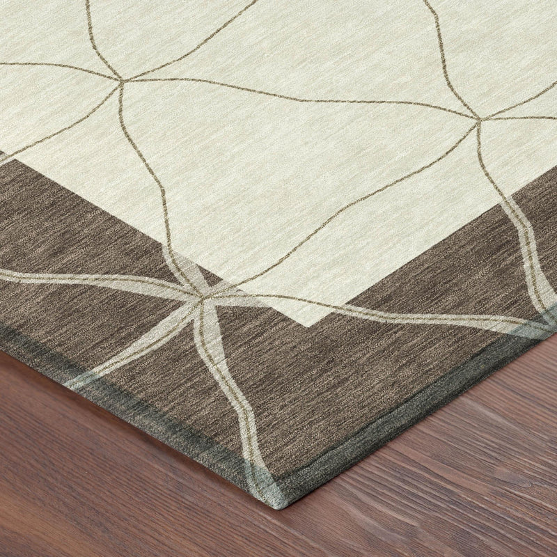 Corner of beige and coffee-brown geometric area rug with stitched border edge.