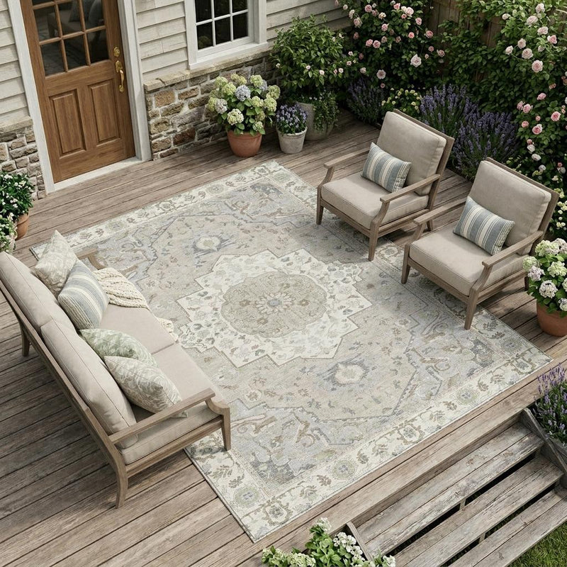Ivory patterned outdoor area rug with central medallion on wooden deck