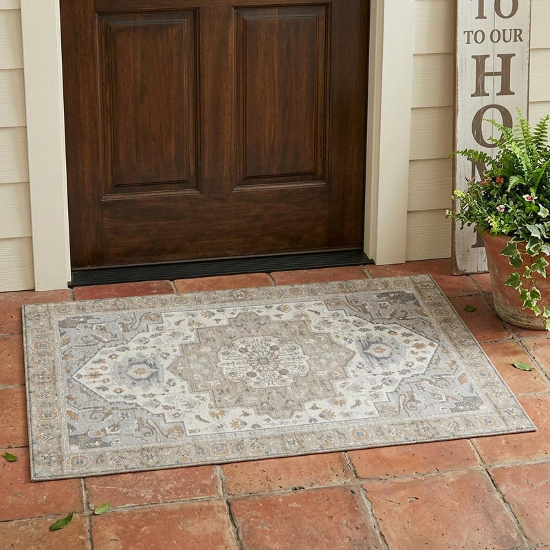 Beige and copper oriental area rug on tile flooring with detailed border pattern