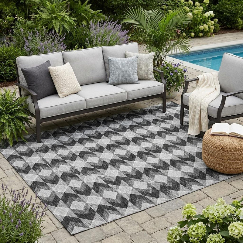 Indoor/outdoor area rug with black, gray, and white diamond zigzag geometric pattern