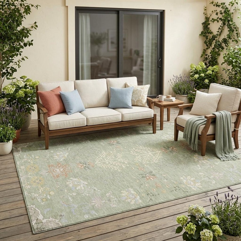 Green and ivory oriental area rug under outdoor seating with floral medallion border