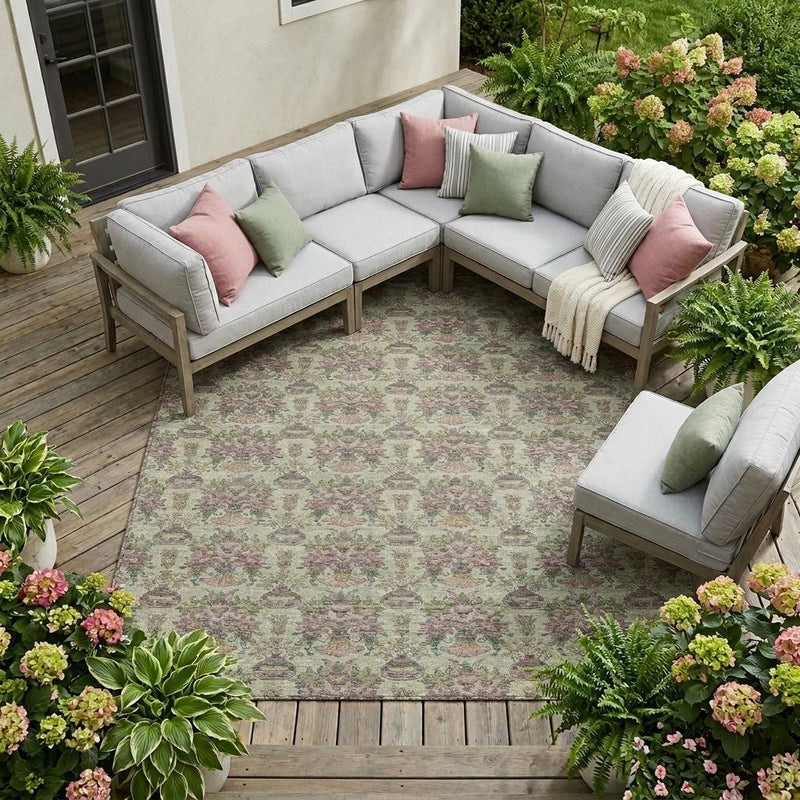 Green-beige outdoor area rug under a patio sectional, floral urn pattern