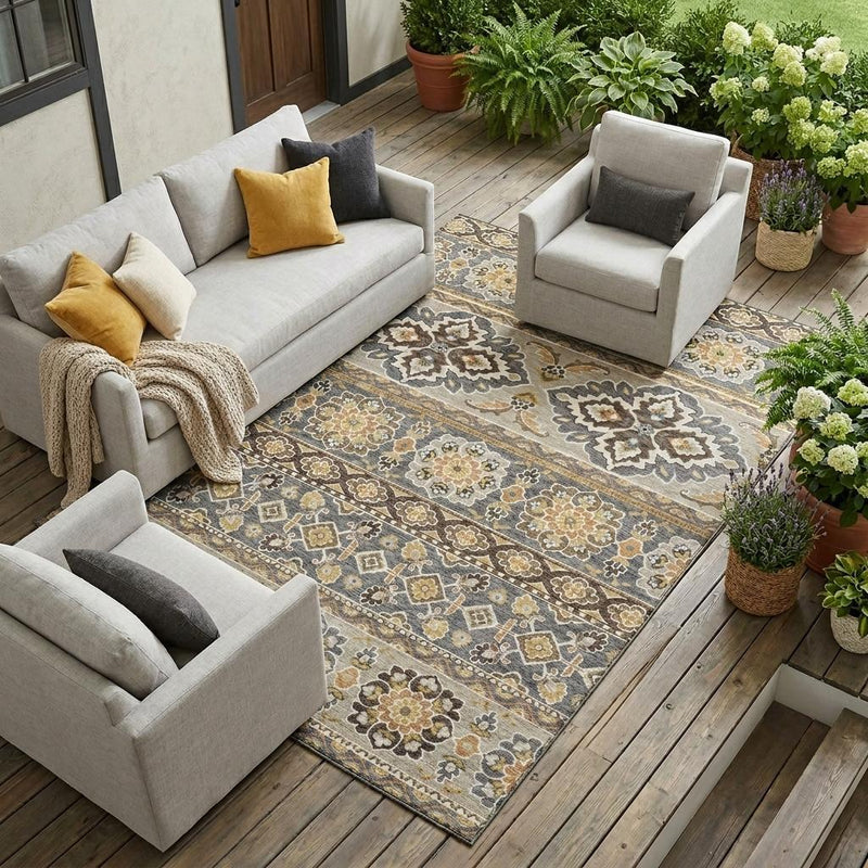 Gray and ivory tribal area rug laid outdoors on a wooden deck with floral borders