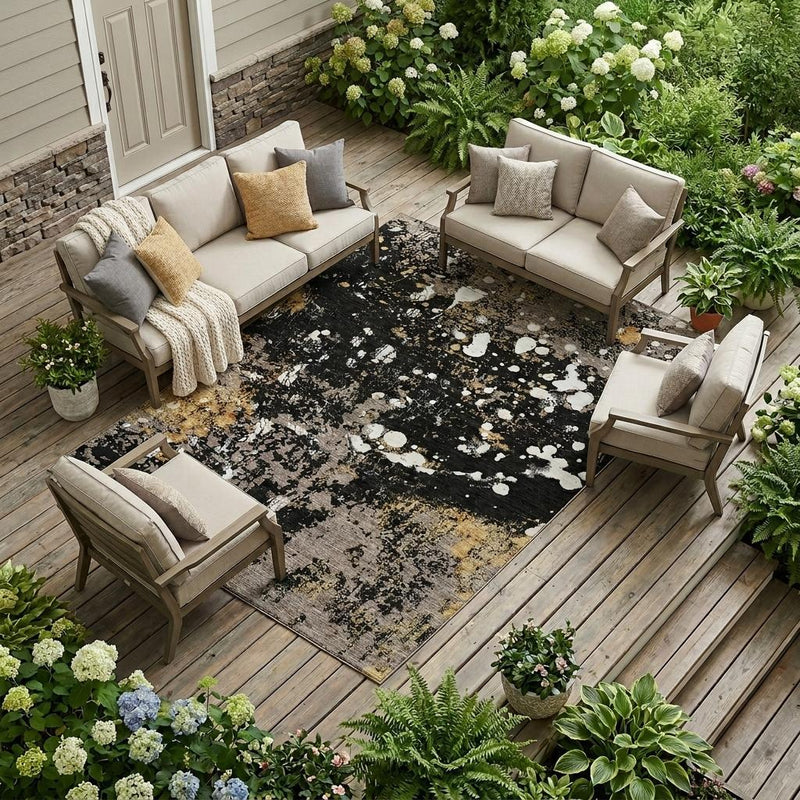 Abstract outdoor area rug laid on wood deck with black and silver-gray splatter