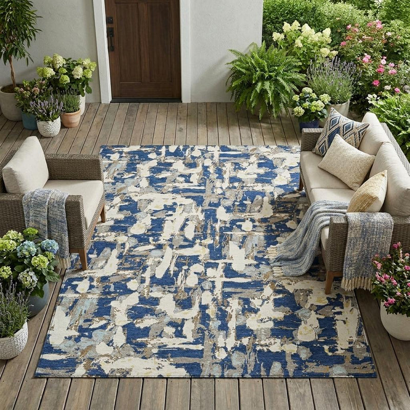 Navy and beige abstract indoor outdoor area rug laid flat on patio floorboards
