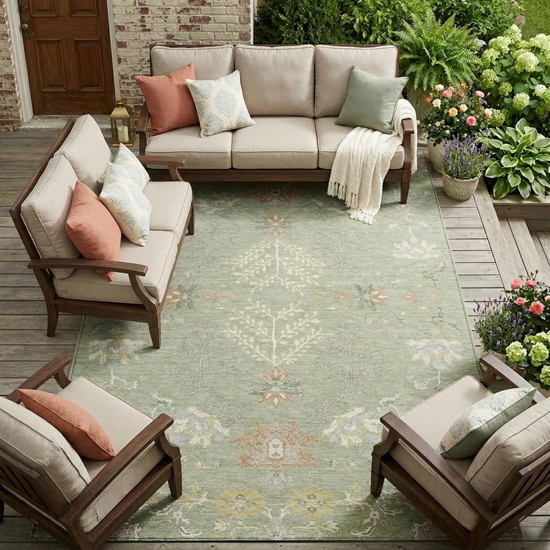 Green oriental area rug under living room seating with ivory floral design