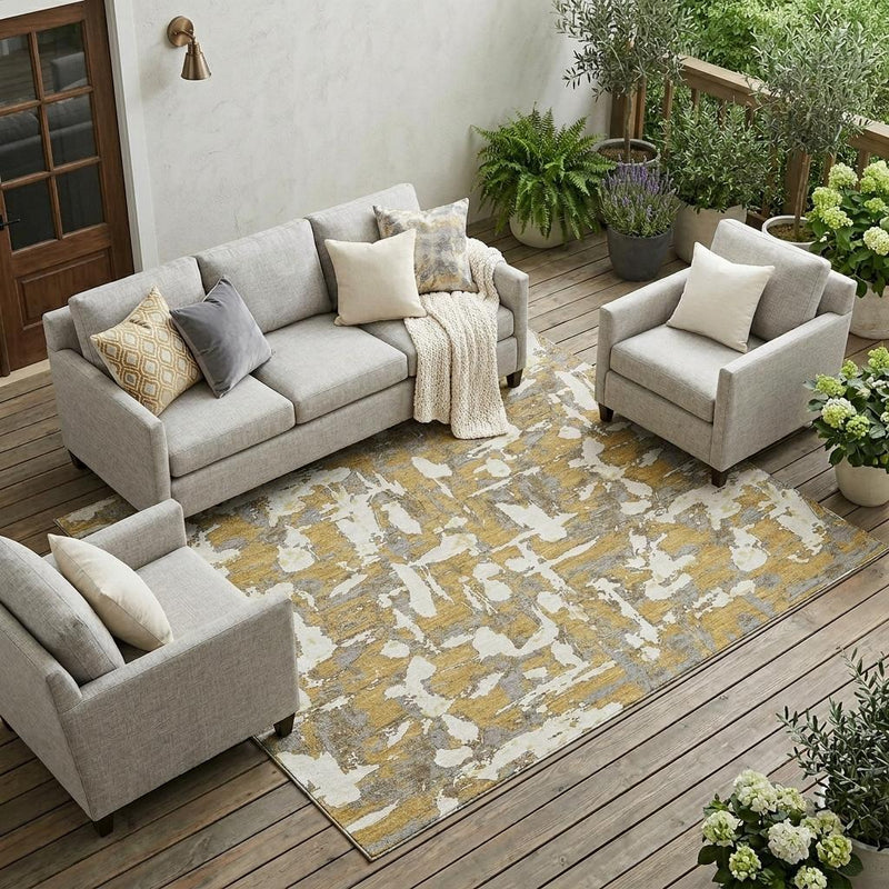 Abstract indoor outdoor area rug with distressed gold and ivory brushstroke design