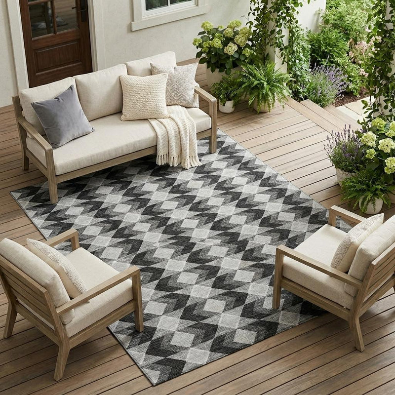Geometric indoor/outdoor area rug under outdoor seating; black, gray, and white diamond design.