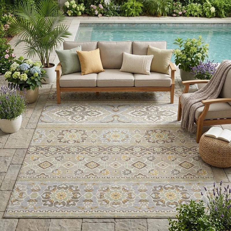 Beige and ivory tribal indoor outdoor area rug under outdoor seating, full design visible.