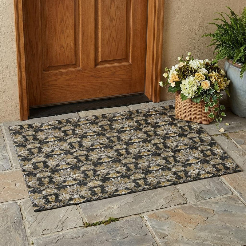 Outdoor indoor area rug on stone patio with black base and gold floral medallions