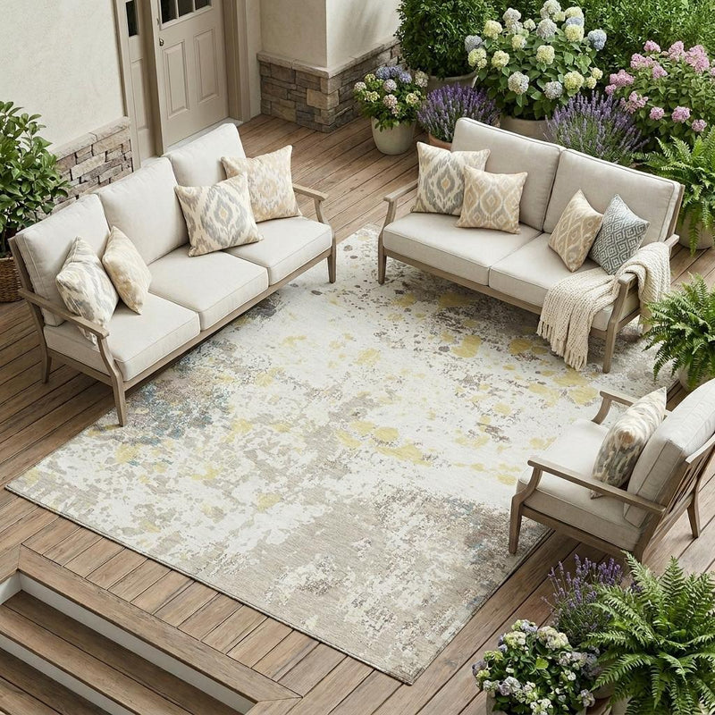Ivory abstract area rug with beige, gray, yellow, and blue distressed splatter pattern