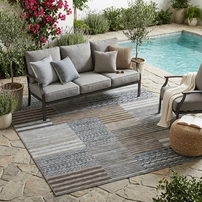 Indoor outdoor area rug with gray, taupe, and blue-striped patch pattern