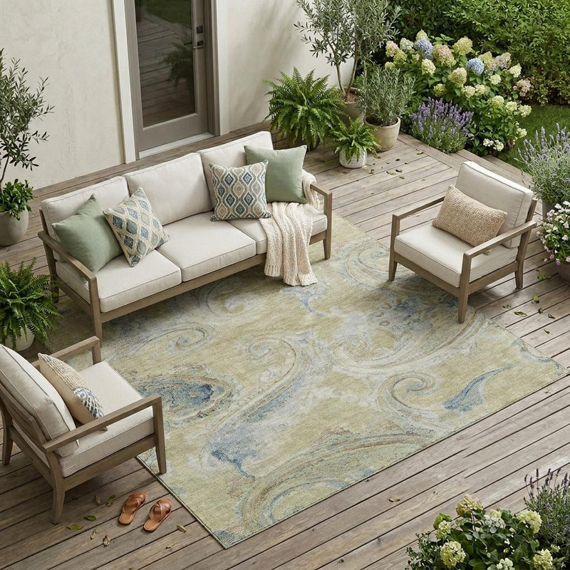 Wheat and light-blue paisley outdoor area rug on a wooden deck with patio seating.