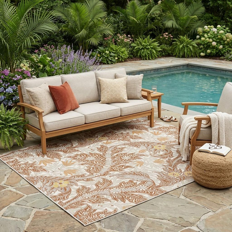 Outdoor-ready botanical area rug with orange and khaki scroll leaves on light base
