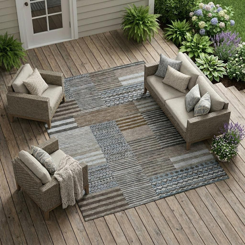 Patchwork indoor/outdoor area rug with striped blocks in gray, beige, brown and blue