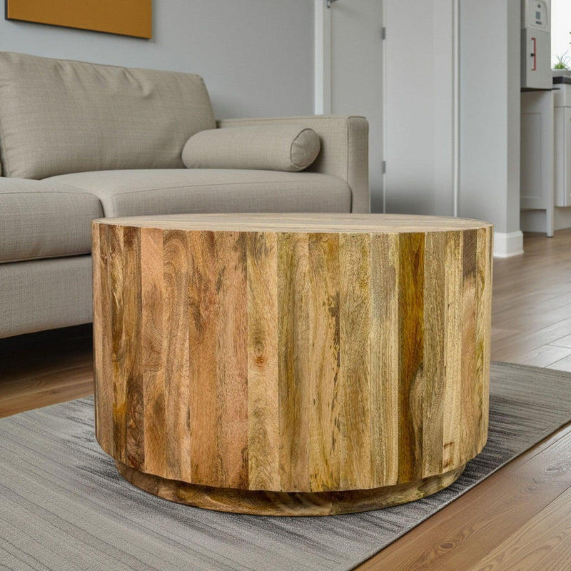Round natural solid-wood drum coffee table with curved apron and visible wood grain