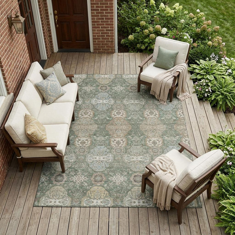 Green and silver floral geometric area rug on outdoor patio with furniture and plants