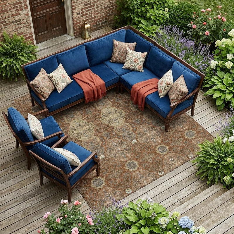 Orange and copper floral area rug under outdoor sectional seating, rectangular design