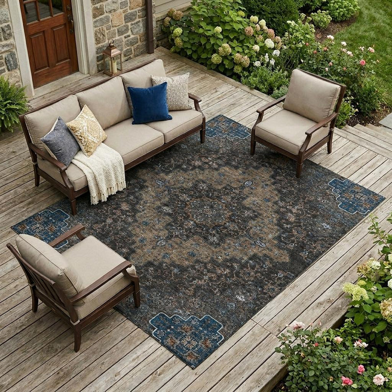Indoor outdoor area rug in patio setting with dark charcoal tone and blue pattern
