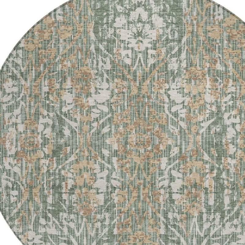 Close-up of round damask area rug pattern in sage green with beige and tan accents