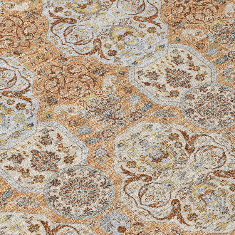 Textured floral medallion rug close-up in copper, gold, cream, and blue-gray tones.