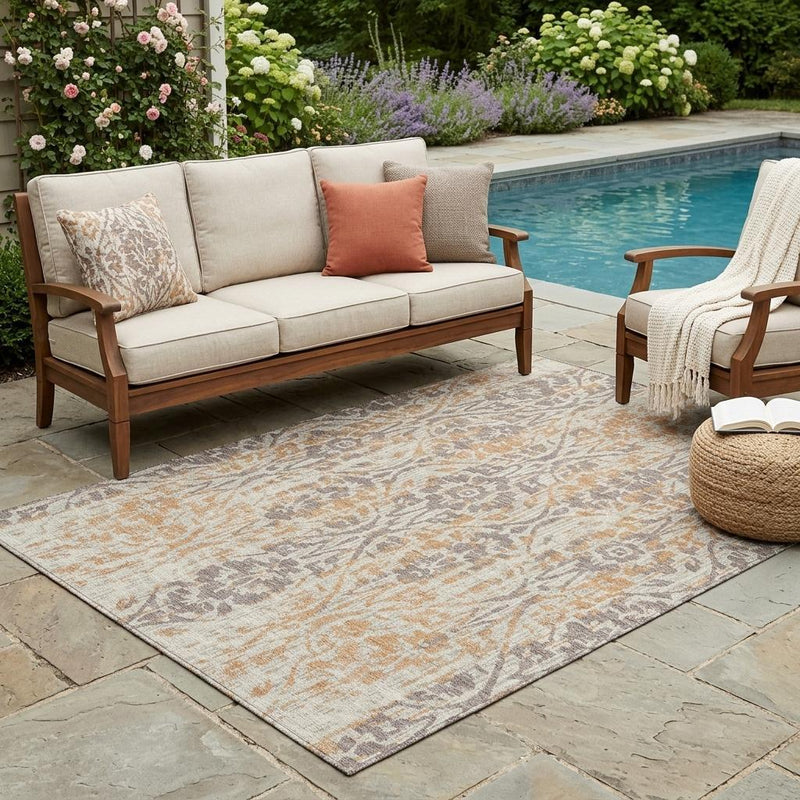 Beige and copper damask washable area rug with distressed ornate motif on outdoor patio