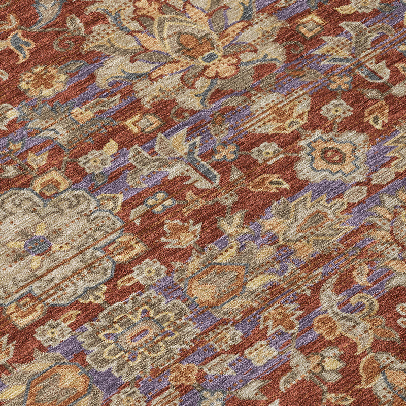 Pattern detail of distressed area rug with ornate florals in rust, beige, and blue tones