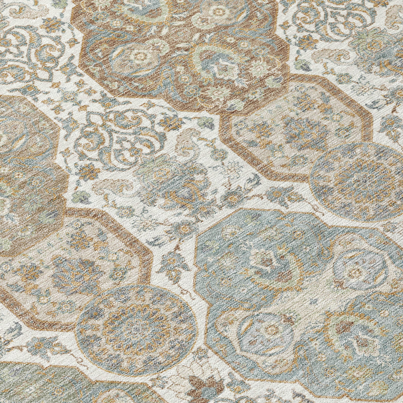 Close-up of ivory, blue-gray and tan rug with distressed medallion floral pattern