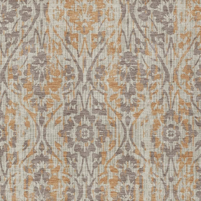 Beige area rug close-up showing gray damask branches with copper speckled details.