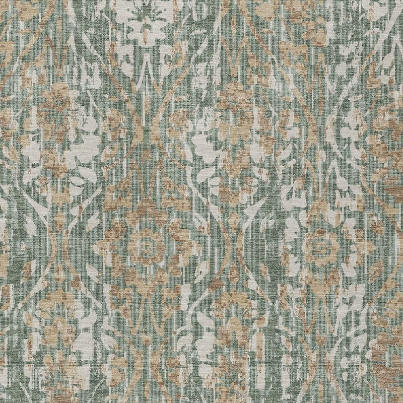 Close-up of green and sage damask area rug with distressed lines and medallion details.