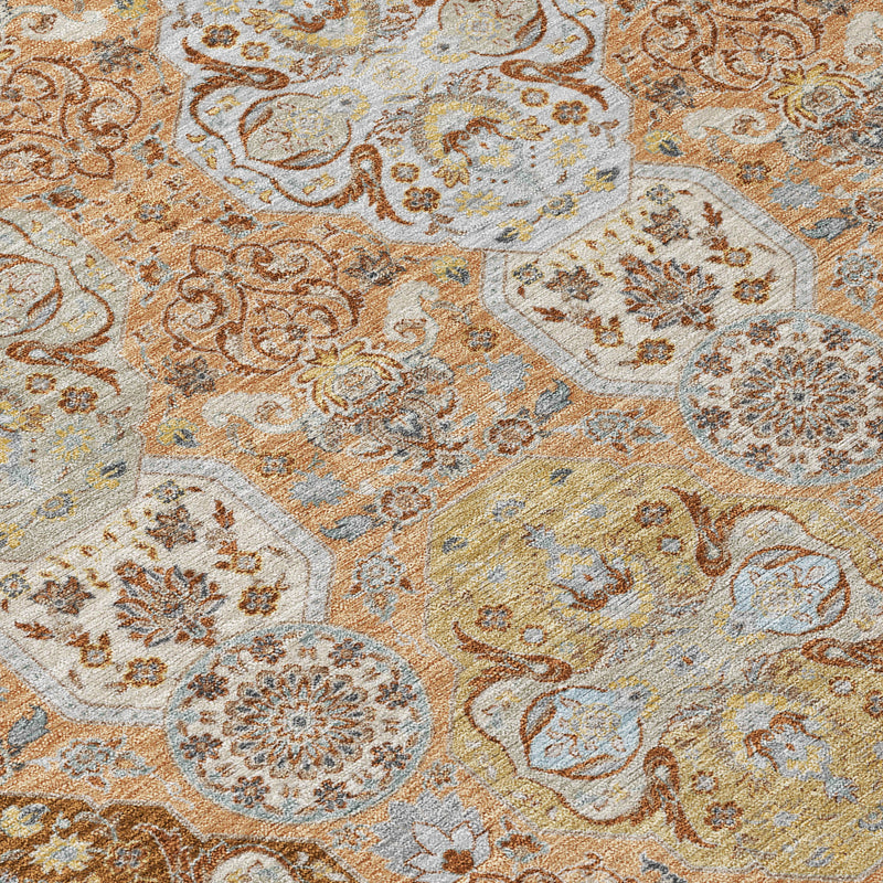Textured close-up of rug showing detailed scrolling florals in orange, tan, and pale blue.