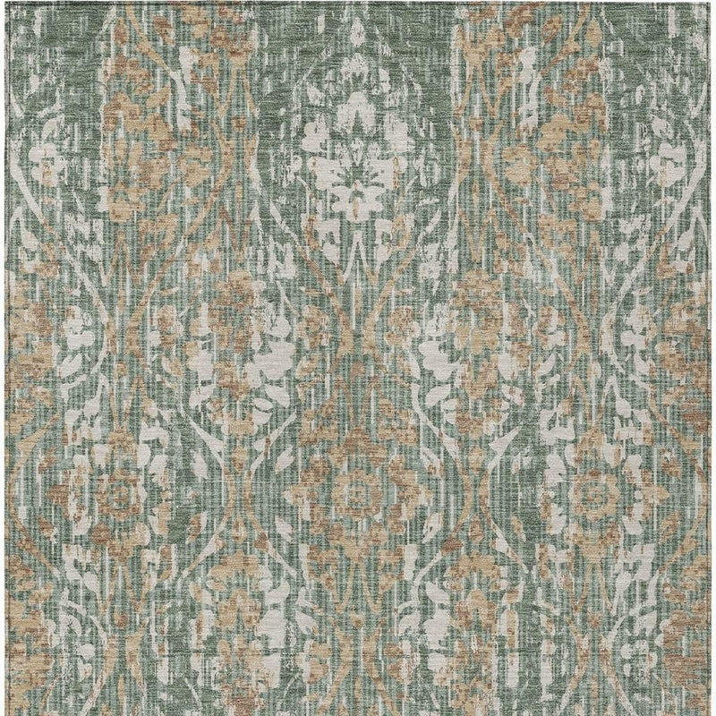 Green and sage damask area rug close-up with allover ornate distressed branching pattern.