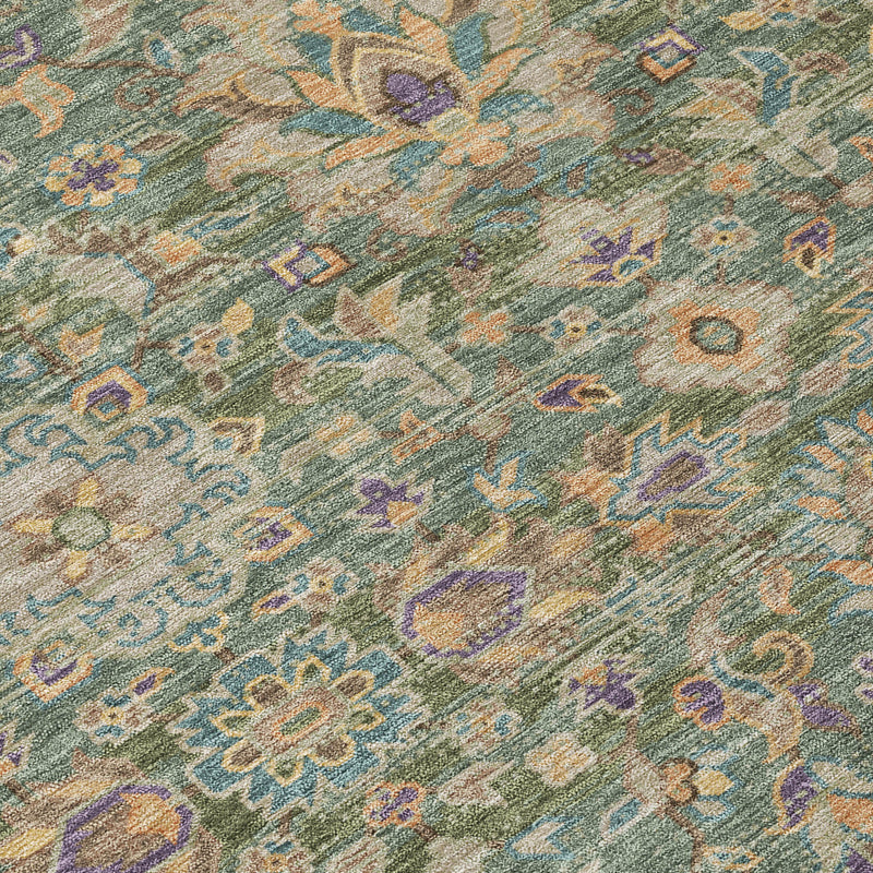 Indoor outdoor area rug close-up, green sage field with small floral and scroll motifs.