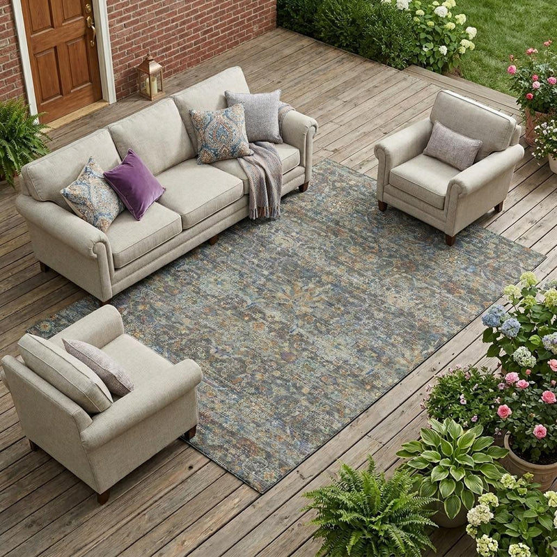 Gray and silver floral medallion area rug outdoors on wood deck, surrounded by seating.