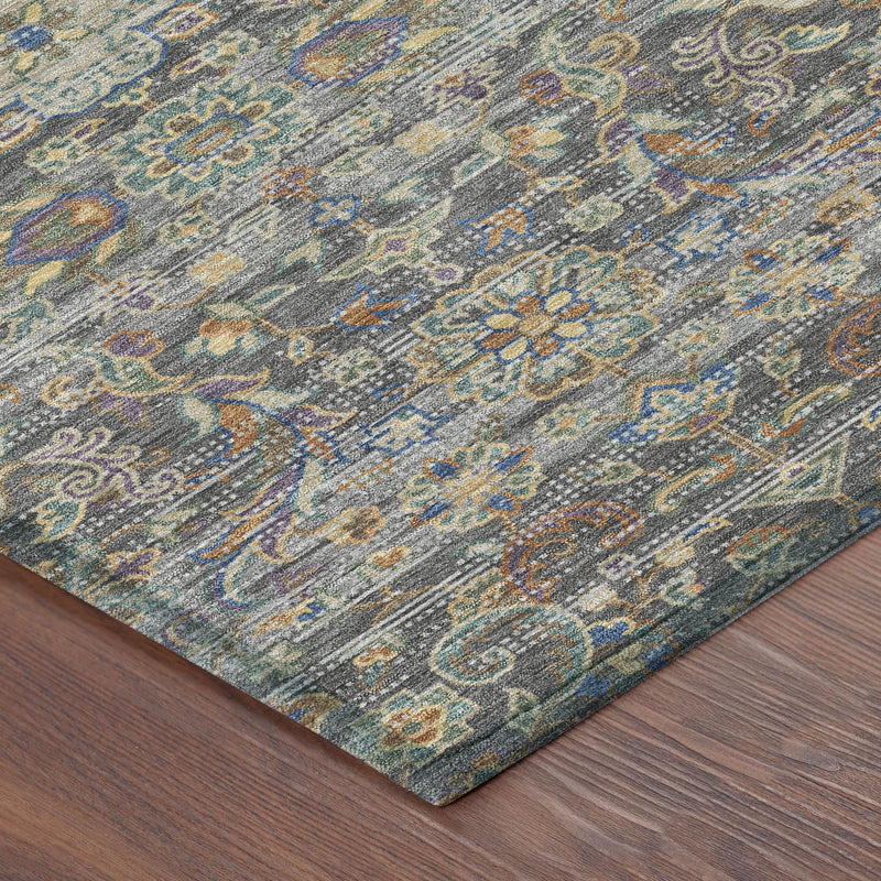 Gray and silver floral medallion area rug corner on wood floor, pattern visible at edge.