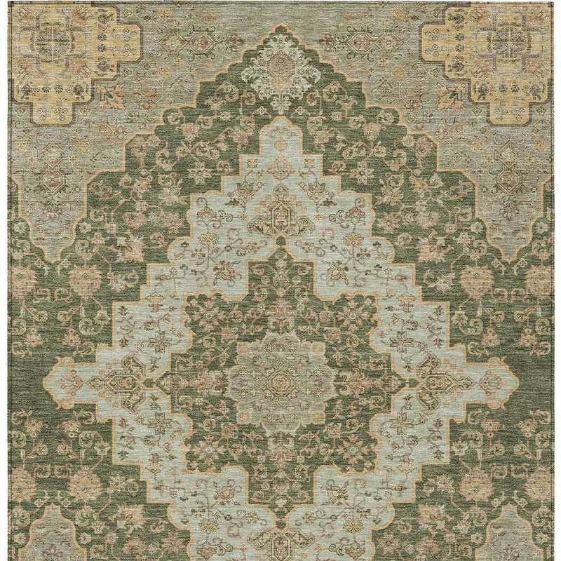 Close, centered view of green and gold medallion area rug with symmetrical pattern