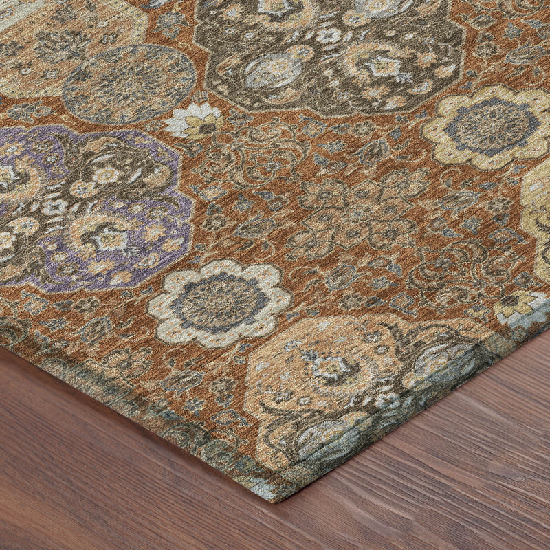 Corner of orange and copper floral area rug showing detailed medallion pattern and texture.