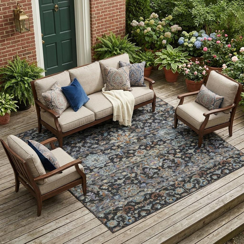 Indoor outdoor area rug with dark charcoal floral medallion design, in living patio setting