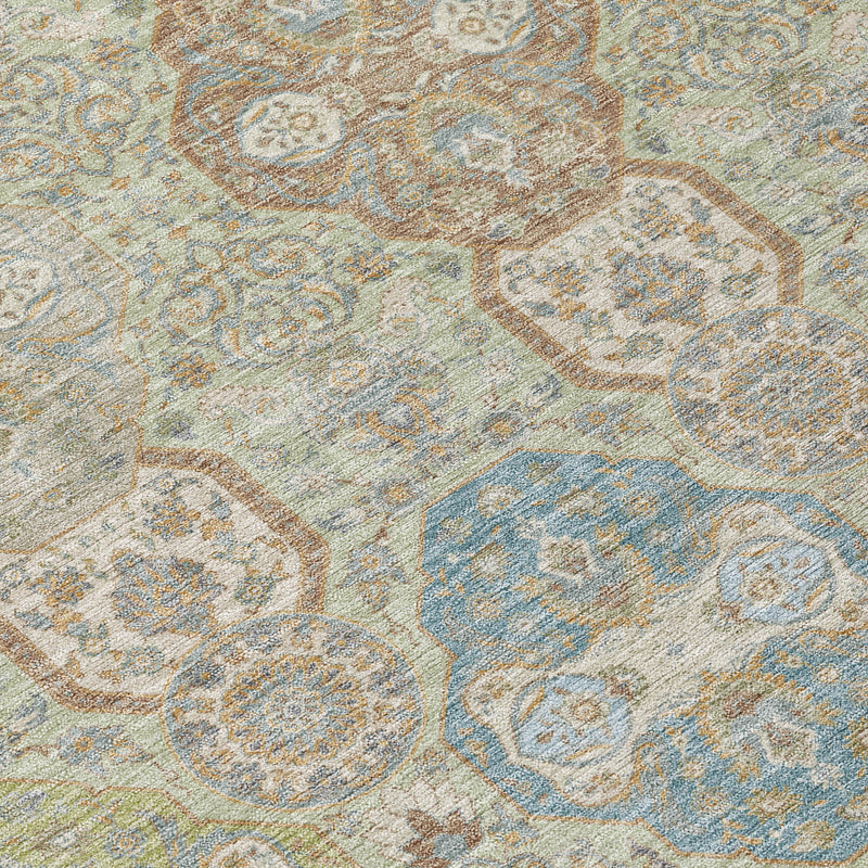 Close-up of sage and blue-green floral medallion rug pattern with distressed detail