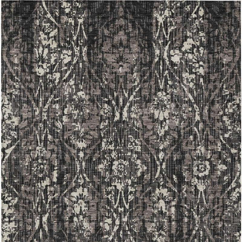 Damask area rug close-up with black and charcoal base and white ornamental motifs.