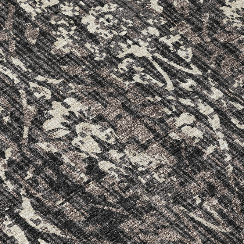 Textured damask rug surface in charcoal with cream and black abstract motifs.