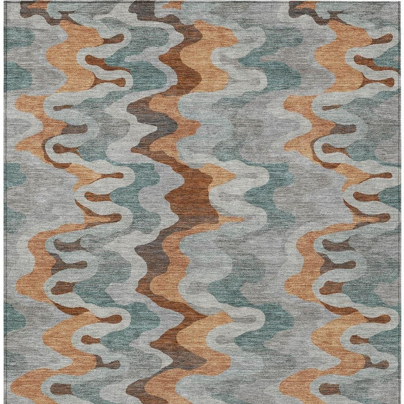 Indoor/outdoor area rug with centered abstract zigzag design in silver, copper, and teal