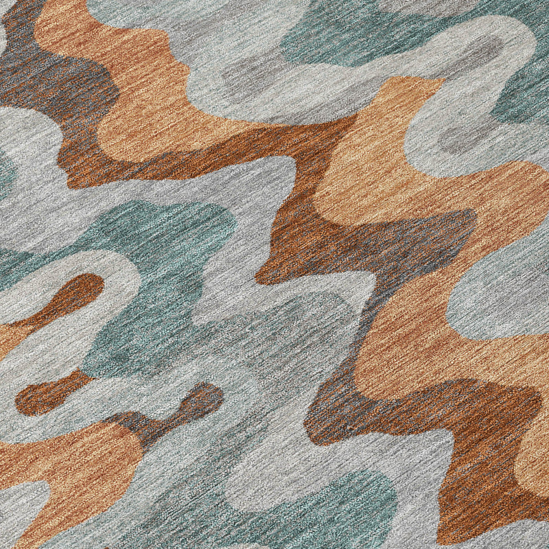 Close-up of abstract zigzag area rug pattern in silver, copper, and teal on light gray