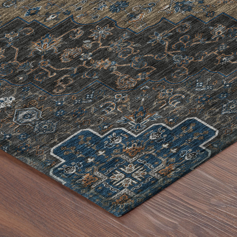 Corner detail of dark charcoal area rug with blue scrollwork and tan medallion motif