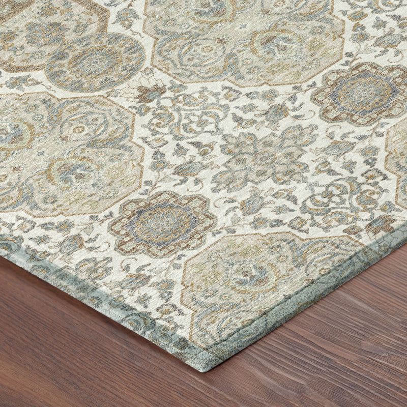 Corner detail of ivory area rug with blue and tan distressed medallion pattern