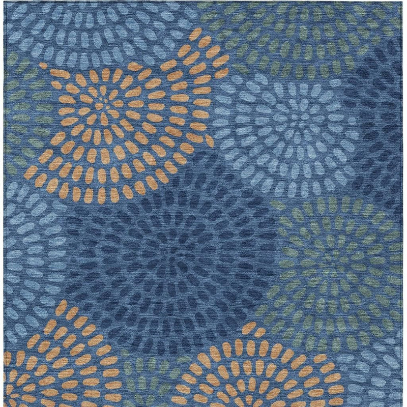 Blue geometric area rug close-up with orange and gray daisy-like dot medallions