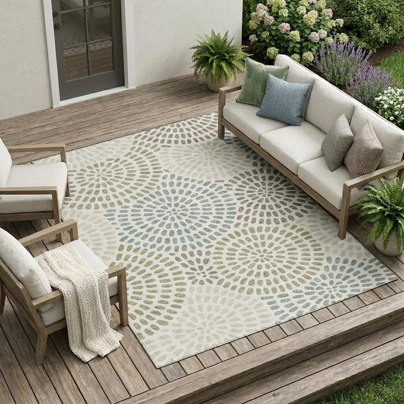 Ivory area rug with sage and dusty blue circular burst pattern
